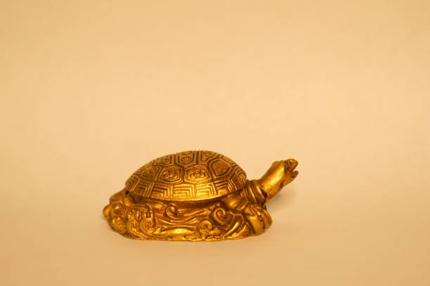 istock Metal turtle with coins on a uniform background. 1272841768