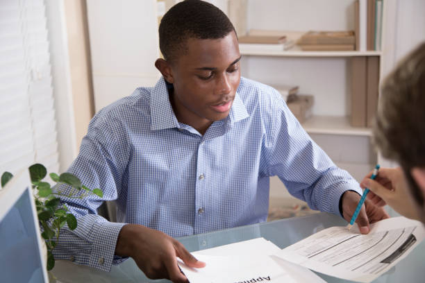 istock Handsome Young Man applying for a loan at his local bank.. 1272844564