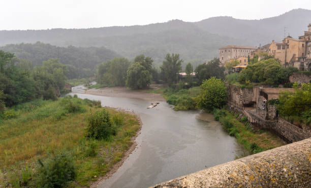 Medieval village in the rain, view of the river from a bridge Medieval village in the rain, view of the river from a bridge lluvia stock pictures, royalty-free photos & images