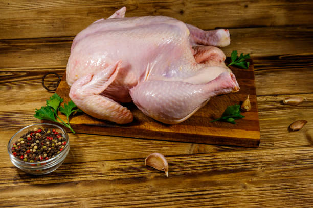 istock Raw whole chicken with spices on a wooden table 1272846116