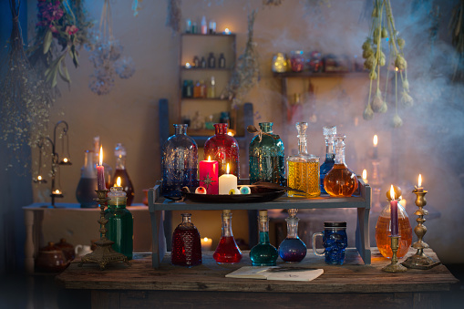 magic potions in  witch's house with burning candles at night