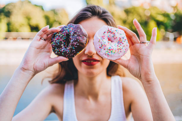 istock Happy woman holding donuts 1272847881