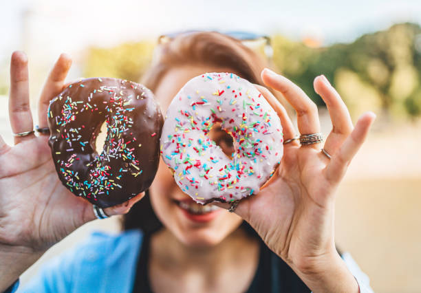istock Happy woman holding donuts 1272848426