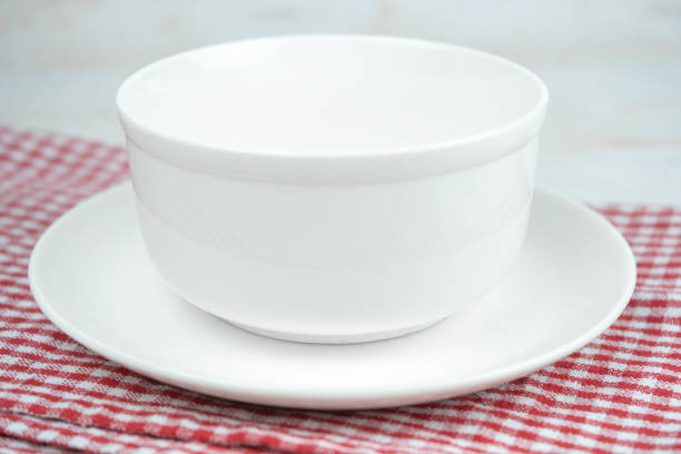 istock White empty ceramic bowl on a plate on a red kitchen plaid towel. 1272848765