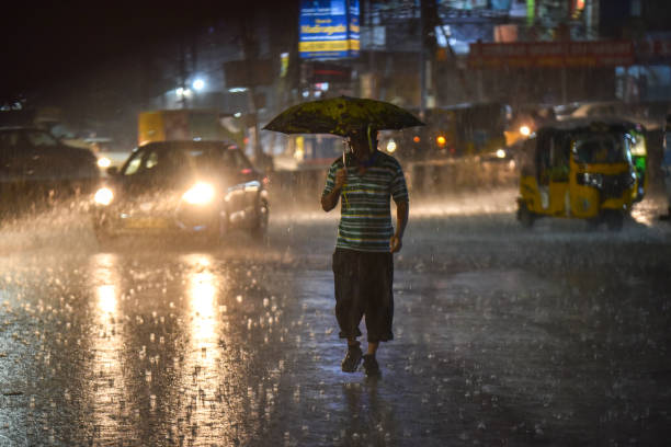 A man crosses a road amid heavy rain in Hyderabad on Wednesday evening. Heavy rains lashes several parts of the city on Wednesday causing many roads in Ameerpet, Mehdipatnam, Tolichowki areas inundated causing serious trouble to traffic in Hyderabad, 16/09/2020 hyderabad india photos stock pictures, royalty-free photos & images