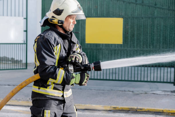 istock close-up of a fireman with a hose spreading water in a fire 1272850450