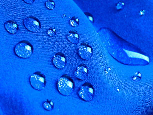 istock Blue waterproof fabric with raindrops close up 1272854213