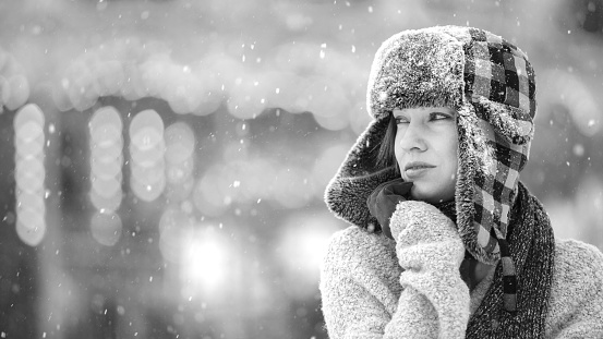 Winter depressed sad girl lonely walking alone with falling snowflakes. Bad feelings stress, anxiety, grief, emotions