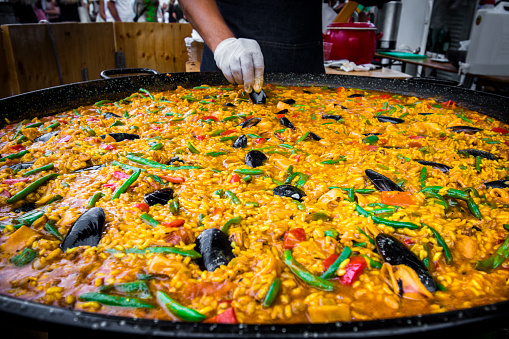 Chef cooking seafood paella on a street food festival.