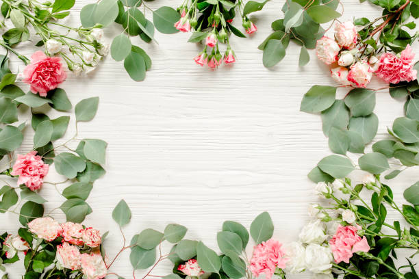 istock frame made of beautiful pink roses and eucalyptus branches on a white background. The apartment lay, top view. Floral frame. Frame of flowers 1272863380