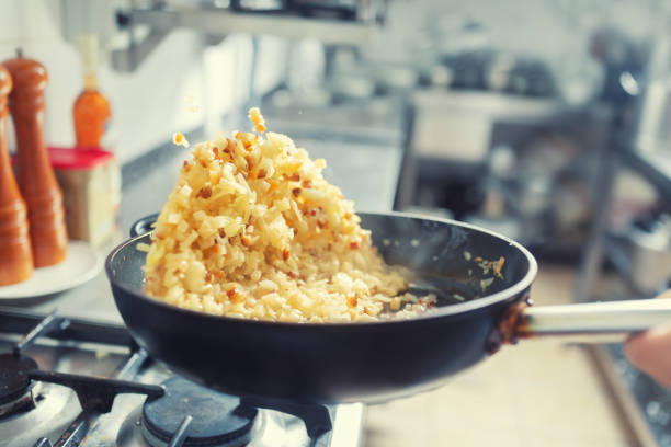 cebula i boczek rłysnął na patelni wewnątrz kuchni. khichri r.osądać w wok pan. - skoczcie cebula zdjęcia i obrazy z banku zdjęć