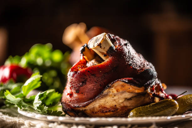 istock Smoked pork ham hock, pork knee served with pickled cucumbers and herbs. 1272863785