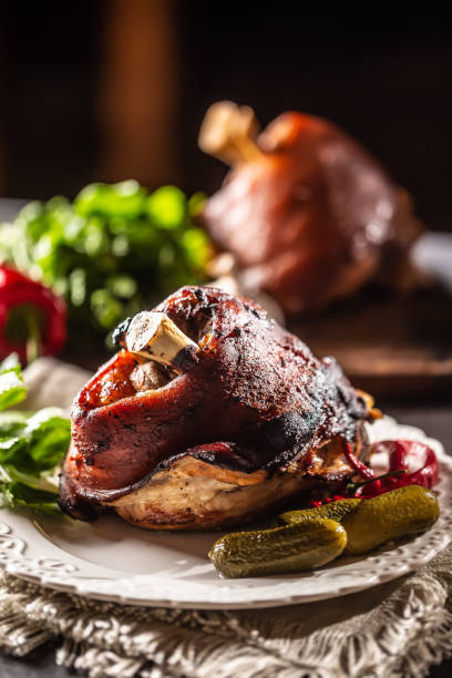 istock Smoked pork ham hock, pork knee served with pickled cucumbers and herbs. 1272863873