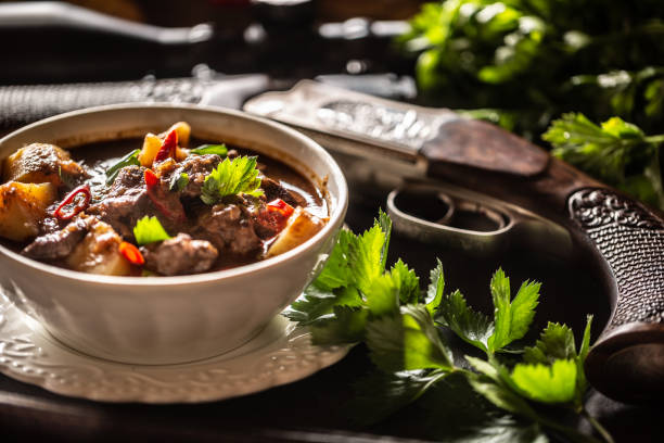 deer stew in a bowl hunting weapon as a decoration. - venison imagens e fotografias de stock