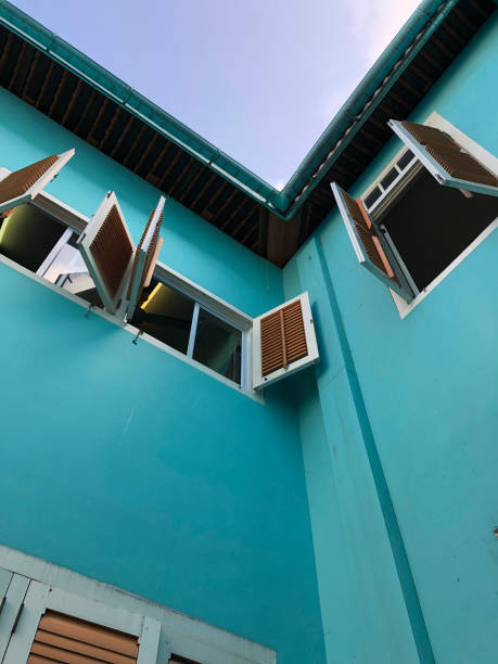 istock Wooden window shutters on an aqua colored building. 1272874060