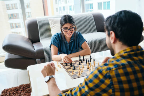 istock Young Man And Woman Having Fun And Playing Chess 1272875202