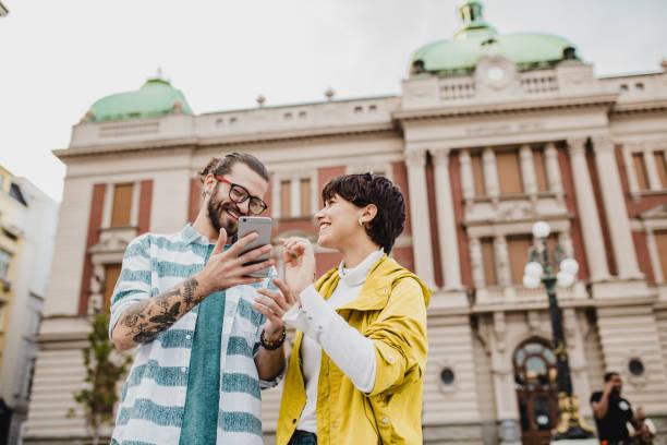 istock Young couple embracing outside and using mobile phone 1272875994