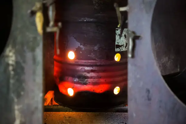 Photo of Red-hot iron barrel in a dark production room