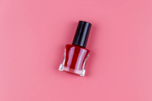 istock Red nail polish bottle on a pastel pink background. Top view 1272885227