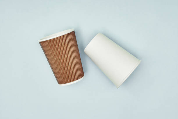 istock Paper cup in hand on a colored background. Eco-friendly materials in a coffee shop, biodegradable disposable tableware. Close up. 1272889755