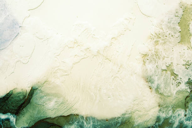 Alcohol ink water. Marble texture. Ivory white cream green mineral stone design art background. Abstract wave foam streak pattern. Creative stained surface. Grunge rock wall effect.