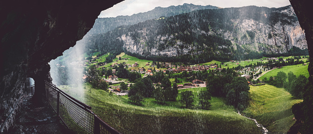 Panorama od Lauterbrunnen Valley, Switzerland with Staubbach waterfall falling over the stark rock cliff above town.