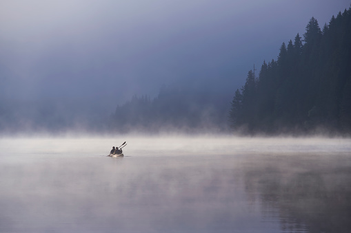 People are kayaking at the lake in the mountains