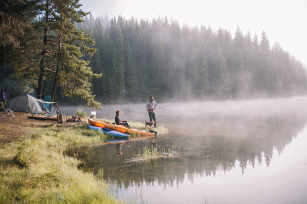Man And A Woman Are Fishing At The Mountains Man and woman are having fun fishing at the mountains rowing boat fishing stock pictures, royalty-free photos & images