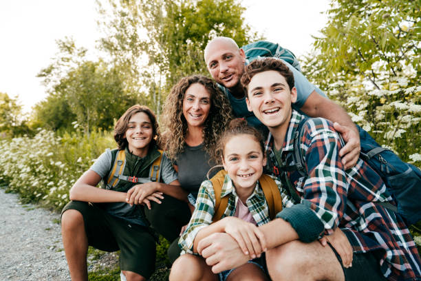 familie mit drei kindern, die vor der kamera lächeln und im park in ontario posieren. - family summer portrait nature stock-fotos und bilder