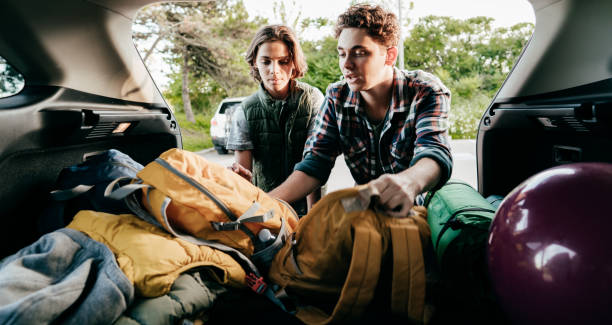 istock Two brothers help load the car. Siblings relocating and stacking backpacks. 1272890328