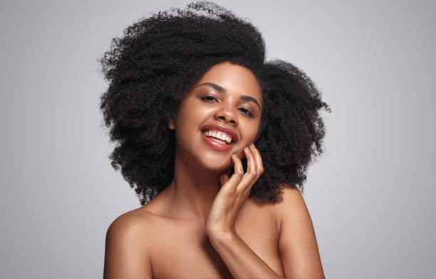 istock Cheerful black woman touching cheek 1272890434