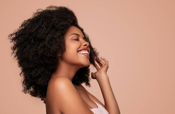 Happy young African American woman on pink background Side view of positive joyful modern African American female model with curly hair and bare shoulders on pink background eyes closed photos stock pictures, royalty-free photos & images