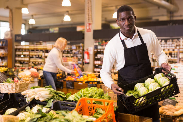 istock Grocery worker arranging vegetables on counter 1272897857