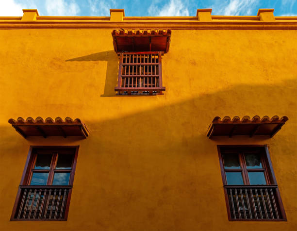 Orange facade with windows in colonial style, Cartagena, Colombia.