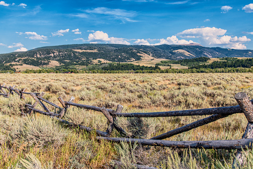 The beautiful landscape of Wyoming; the prairie with an old worn fence in foreground.