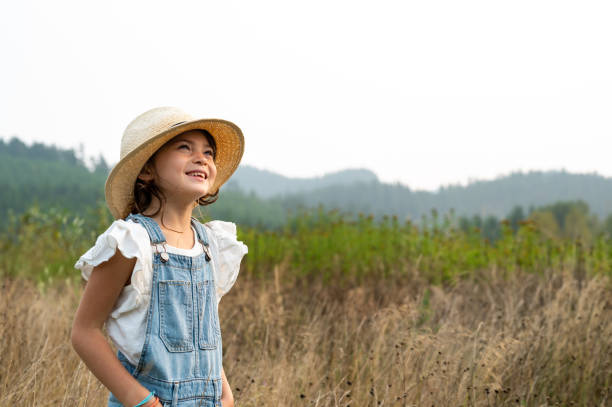Young girl looking to the future on a farm. confident young girl looking to the distance. Girl outside in nature.