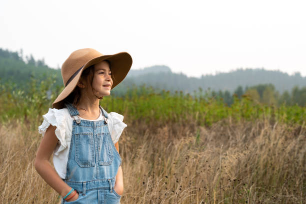 Young girl looking to the future on a farm. confident young girl looking to the distance. Girl outside in nature.
