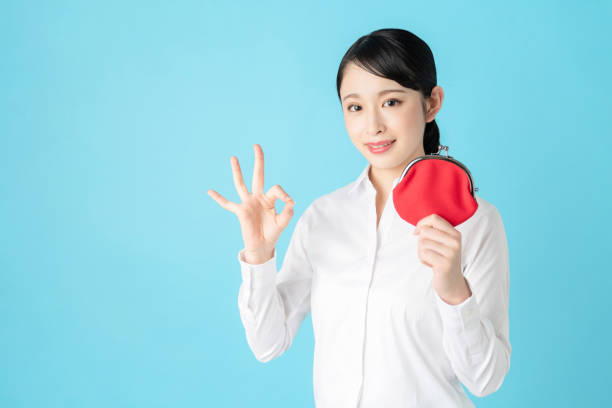 Young asian girl holding a coin purse. Young asian girl holding a coin purse. reduction looking at camera finance business stock pictures, royalty-free photos & images