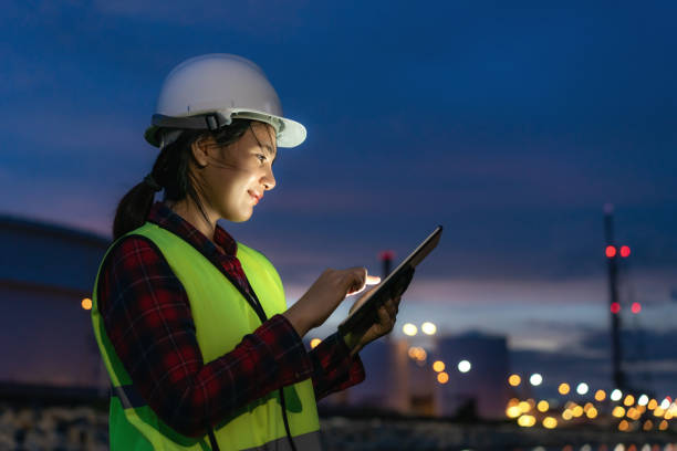 asiatische frau petrochemische ingenieur arbeiten in der nacht mit digitalen tablet in öl-und gas raffinerie fabrik fabrik in der nacht für inspektor sicherheit qualitätskontrolle. - petrochemical plant stock-fotos und bilder