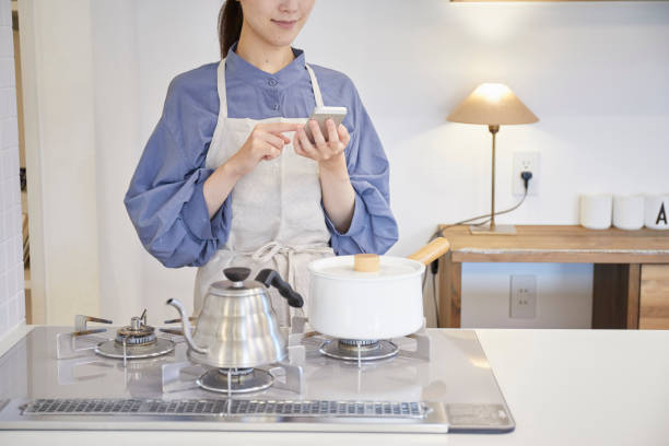istock A woman operating home appliances with a smartphone 1272928231