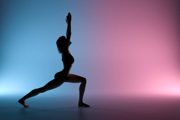 istock Young fit woman practicing yoga. Neon lights. 1272929830