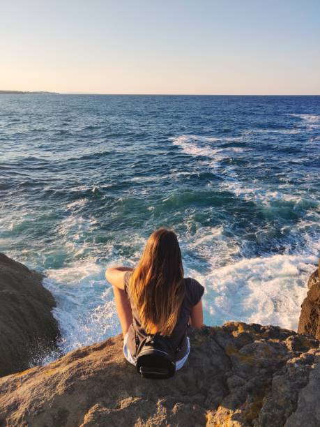 istock Beautiful young woman on a sea-shore 1272930486