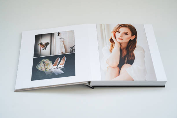 open wedding photo book. wedding photo book. flipping through a wedding photobook with thick pages on a white table. convenient, beautiful and long-lasting storage of photos from photo sessions. scrapbook stock pictures, royalty-free photos & images