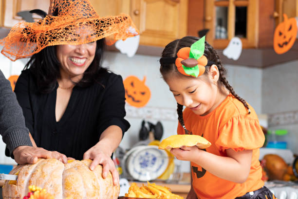 istock A woman with a kid carving a pumpkin 1272930763