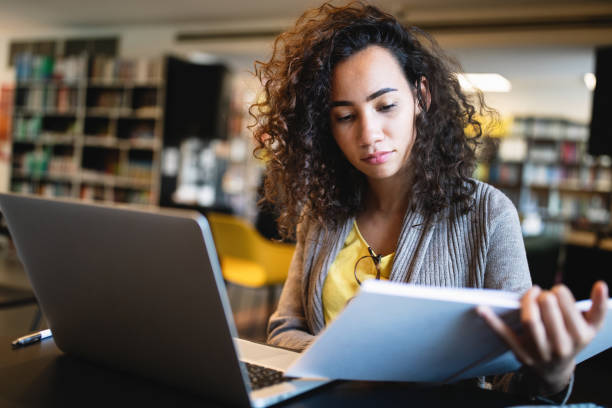 istock Young beautiful student girl working, learning in college library 1272930993