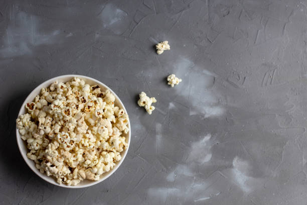istock Popcorn in white bowl on grey table. Top view with copyspace 1272931824