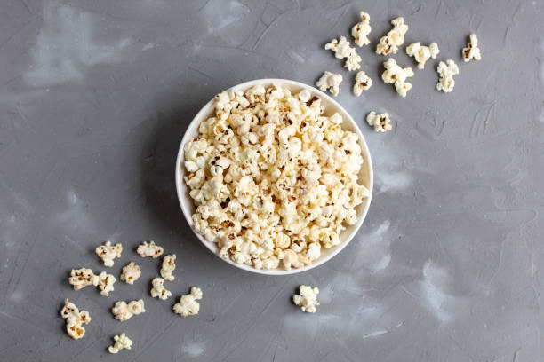 istock Popcorn in white bowl on grey table. Top view with copyspace 1272931826