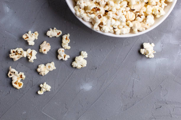 istock Popcorn in white bowl on grey table. Top view with copyspace 1272931829