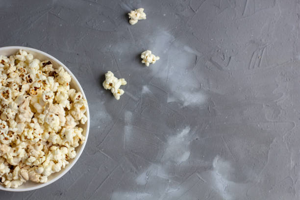istock Popcorn in white bowl on grey table. Top view with copyspace 1272931831