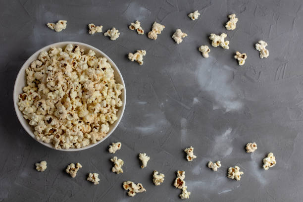 istock Popcorn in white bowl on grey table. Top view with copyspace 1272931834
